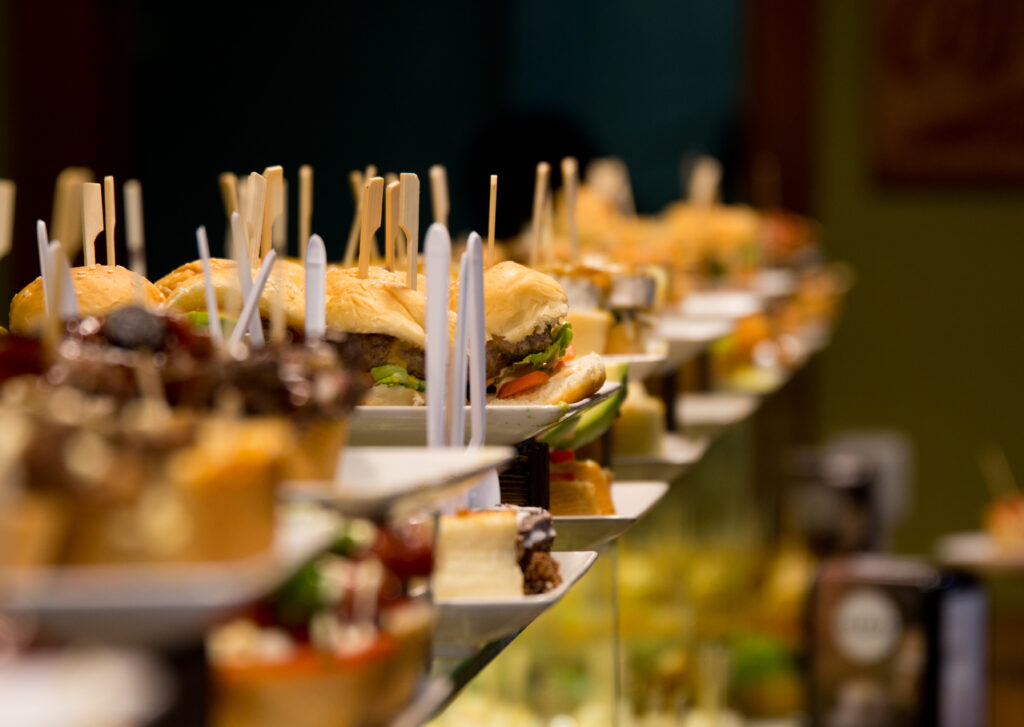 Closeup of the pinchos with wooden sticks on top. Catering products on the plates.